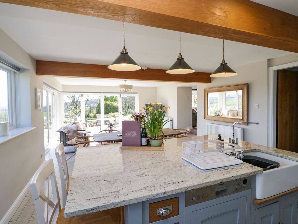 A kitchen with a large island and dining area at Barn Howe in Lyth near Levens