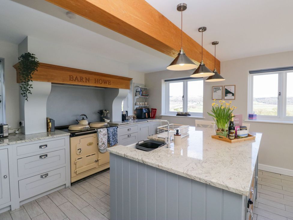 A kitchen with a stove and kitchen island at Barn Howe in Lyth near Levens