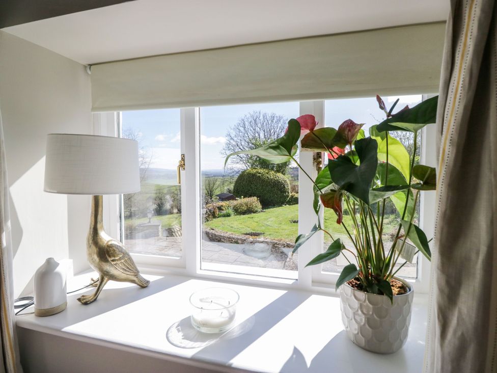 A living room with a lamp and plant on the windowsill at Barn Howe Lyth near Levens