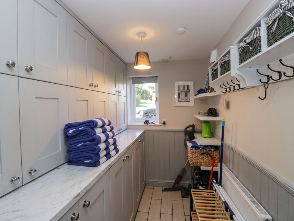 A utility room with stacked towels and storage at Barn Howe in Lyth near Levens