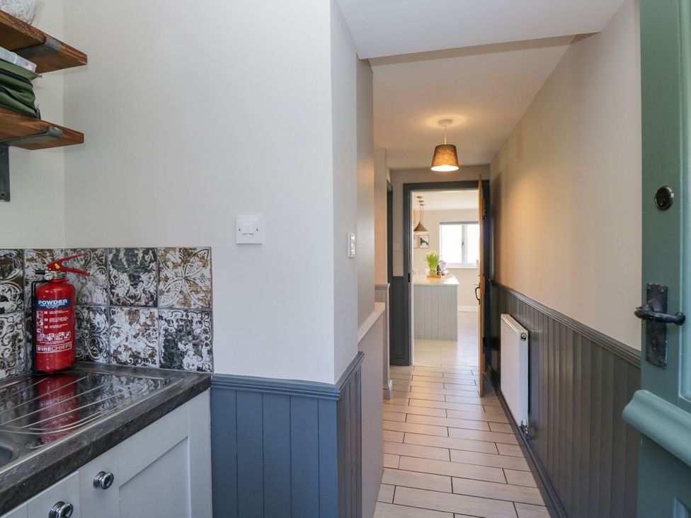 A hallway with a sink and fire extinguisher at Barn Howe in Lyth near Levens