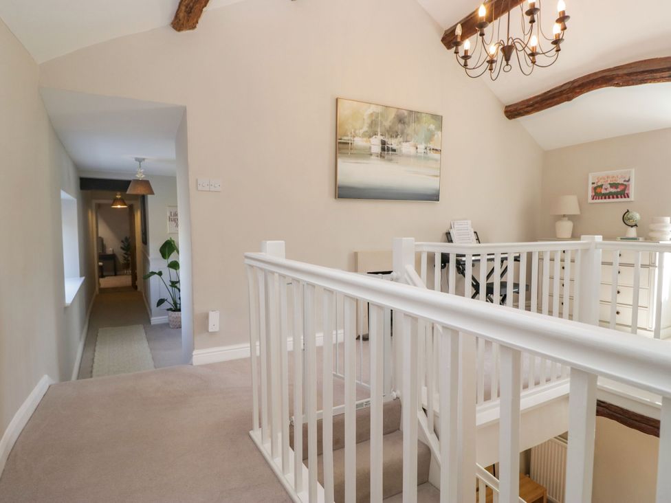 A hallway with staircase and console table at Barn Howe in Lyth near Levens