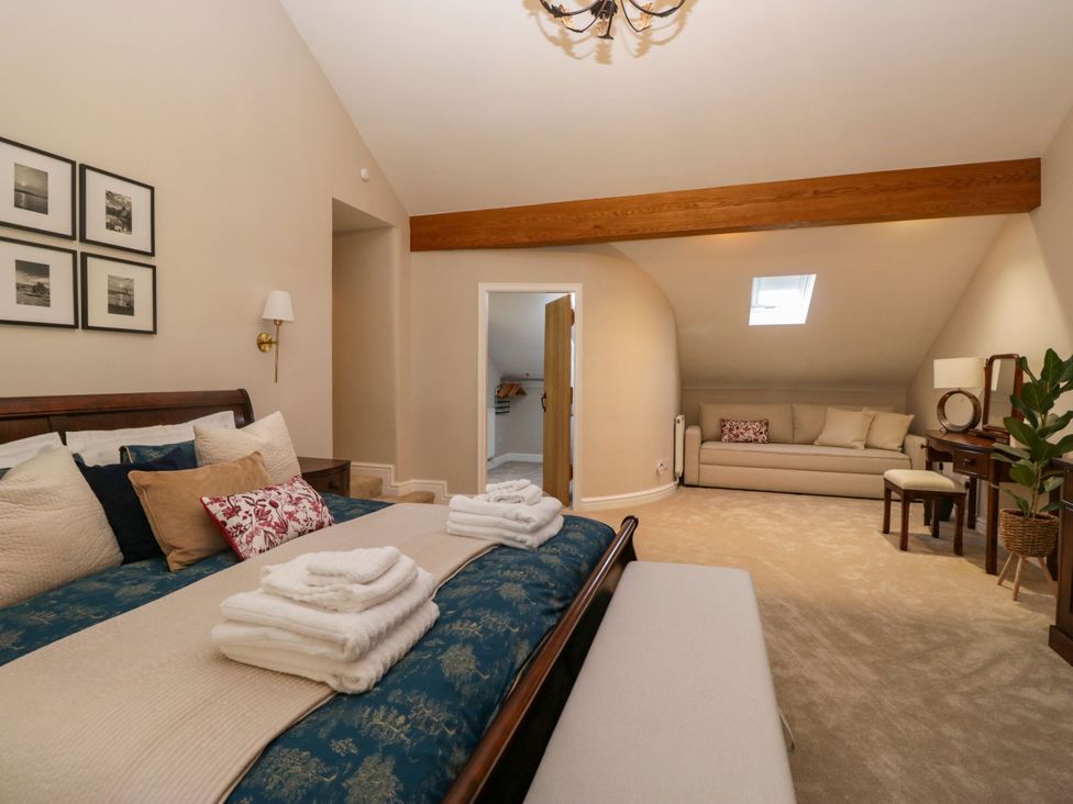 A bedroom with a bed and sofa at Barn Howe in Lyth near Levens