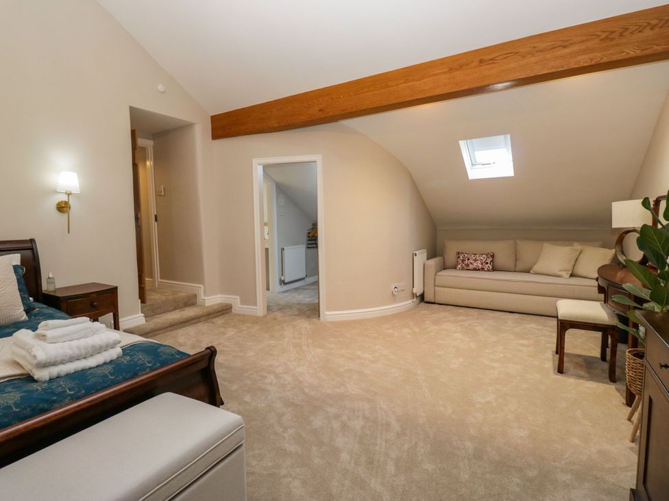 A bedroom with a bed and sofa at Barn Howe in Lyth near Levens