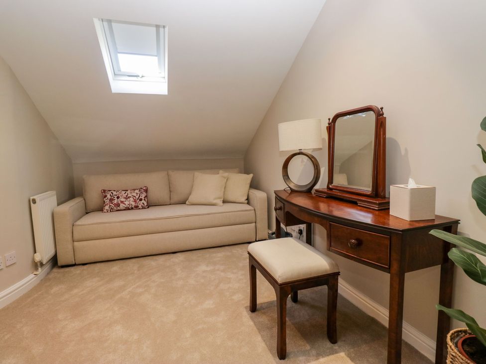 An attic with a sofa and vanity table at Barn Howe Lyth near Levens