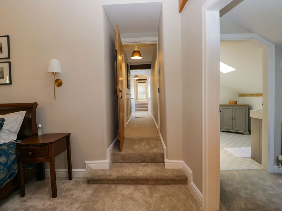 A hallway with stairs and a nightstand in Barn Howe Lyth near Levens