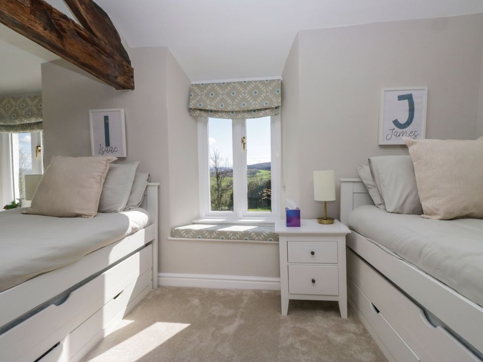 A bedroom with two beds and a window at Barn Howe Lyth near Levens