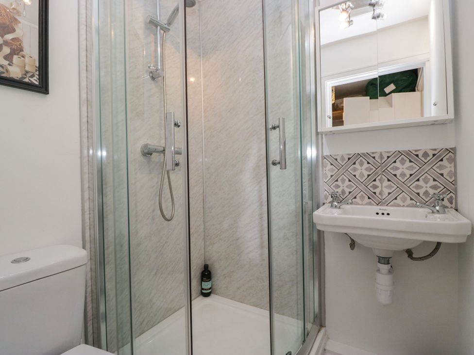 A bathroom with a shower, sink, and toilet at Barn Howe in Lyth near Levens