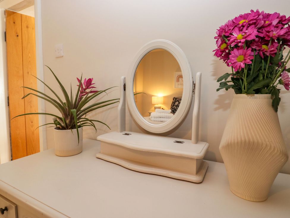 A table with a mirror and flower vase at Barn Howe in Lyth near Levens