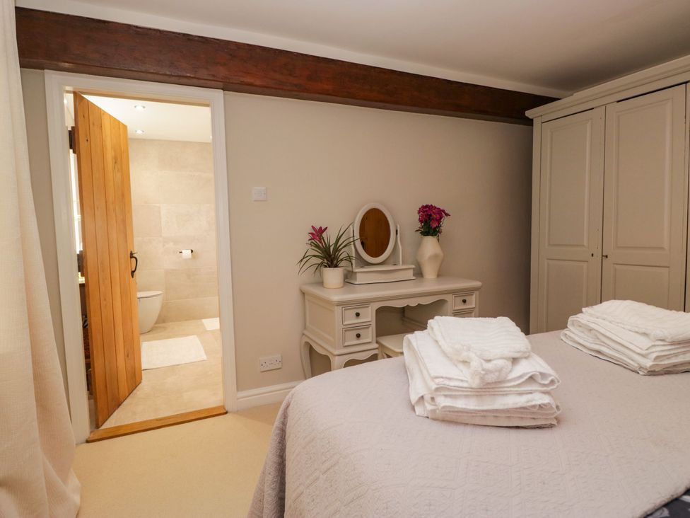 A bedroom with a bed and a vanity at Barn Howe in Lyth near Levens