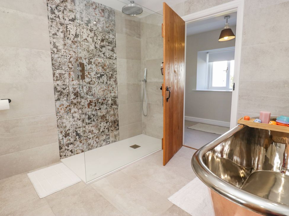 A bathroom with a shower and bathtub at Barn Howe in Lyth near Levens