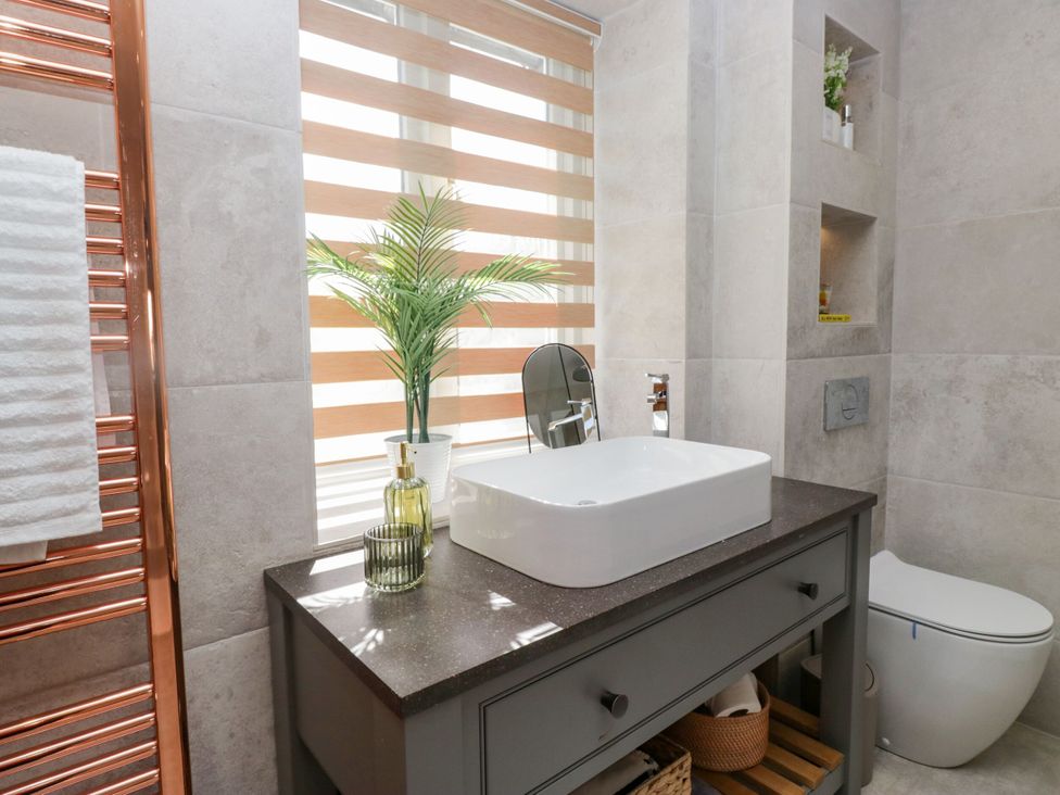 A bathroom with a wash basin and toilet at Barn Howe Lyth near Levens