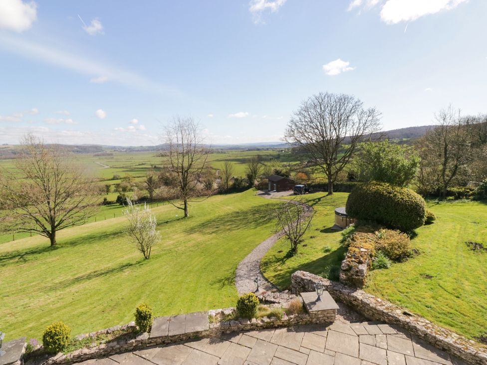 An outdoor view of a garden with trees and a shed at Barn Howe Lyth near Levens