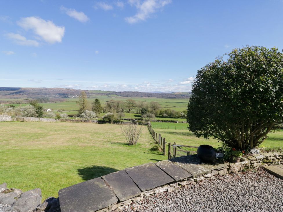A view of a rural landscape with trees and a stone path at Barn Howe Lyth near Levens