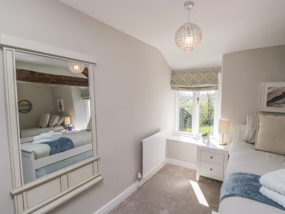 A bedroom with a bed and a lamp at Barn Howe in Lyth near Levens