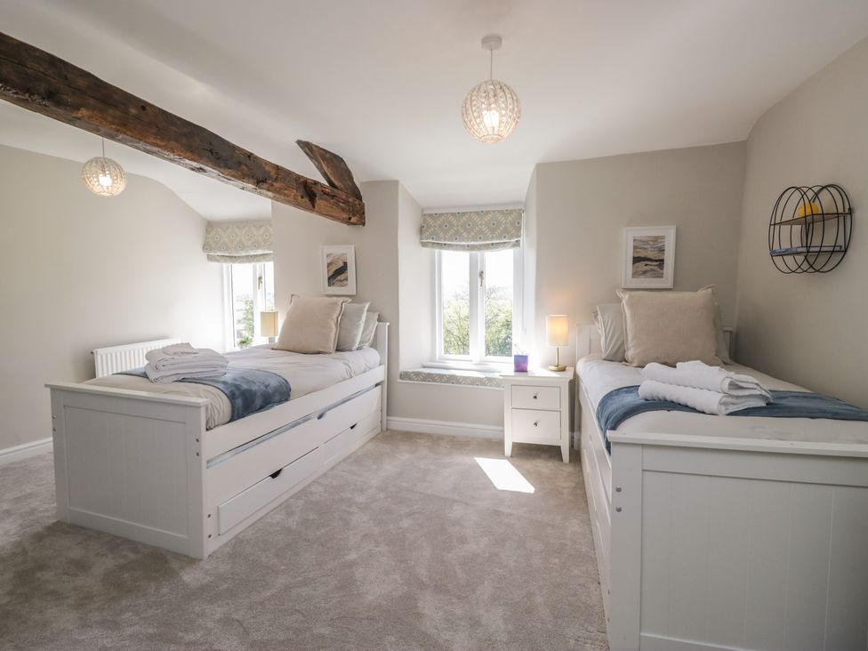 A bedroom with two beds and a window at Barn Howe in Lyth near Levens