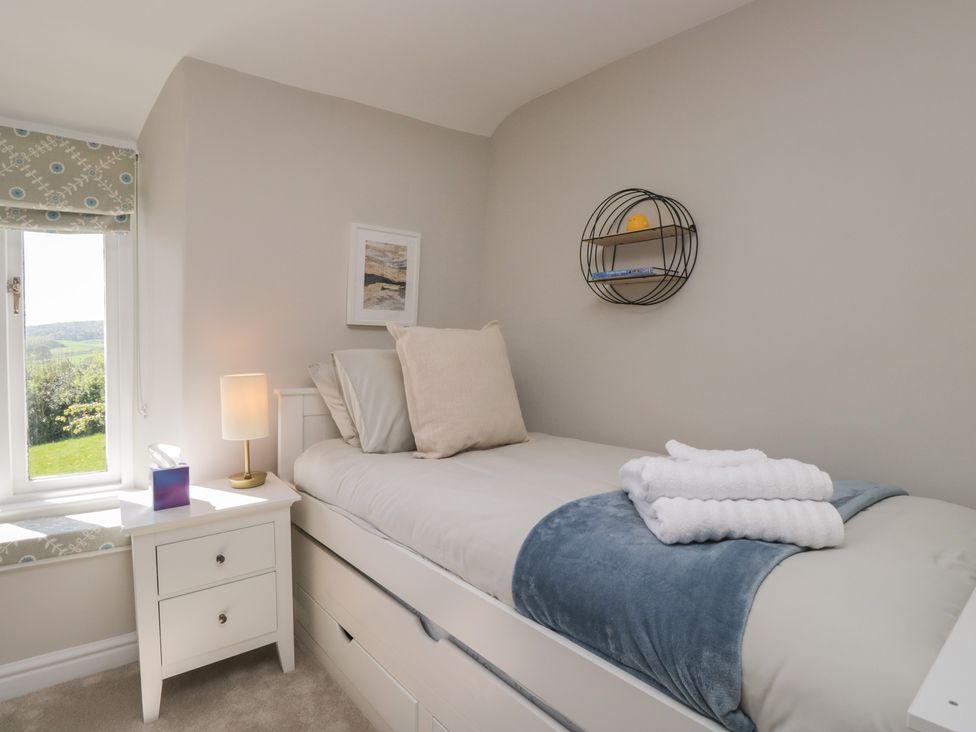 A bedroom with a bed and a lamp at Barn Howe in Lyth near Levens