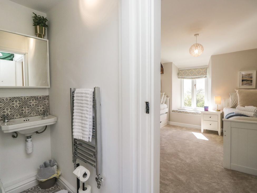 A bathroom with sink and mirror at Barn Howe in Lyth near Levens