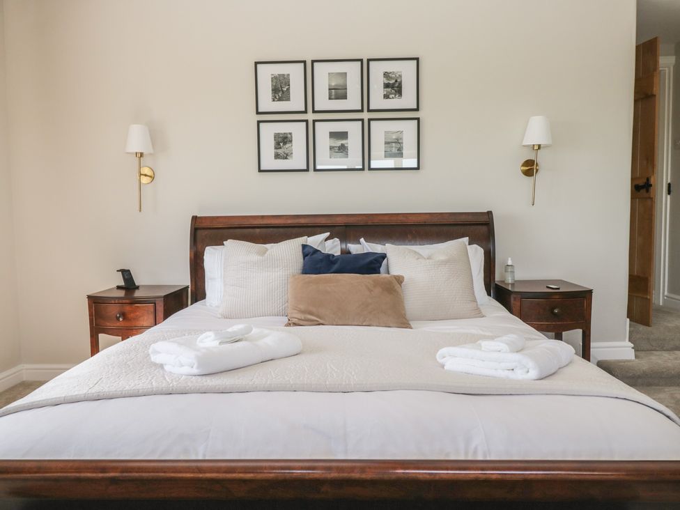 A bedroom with a bed and bedside table at Barn Howe in Lyth near Levens