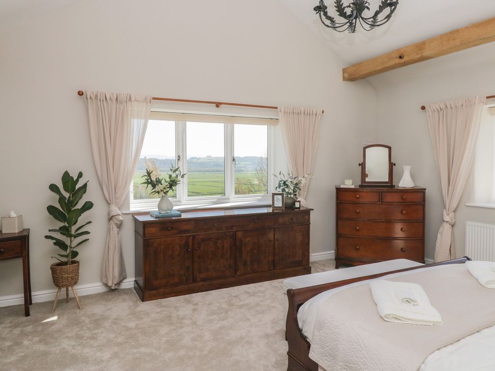A bedroom with a bed and a dresser at Barn Howe in Lyth near Levens
