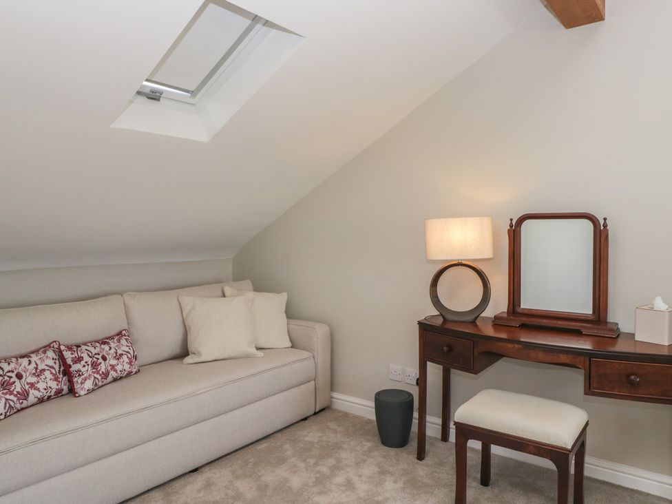 A dressing room with a sofa and vanity table at Barn Howe in Lyth near Levens
