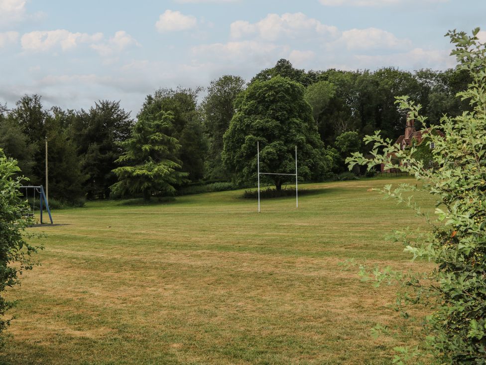 A rugby field with a swing set and trees at Flat 1 Winchester