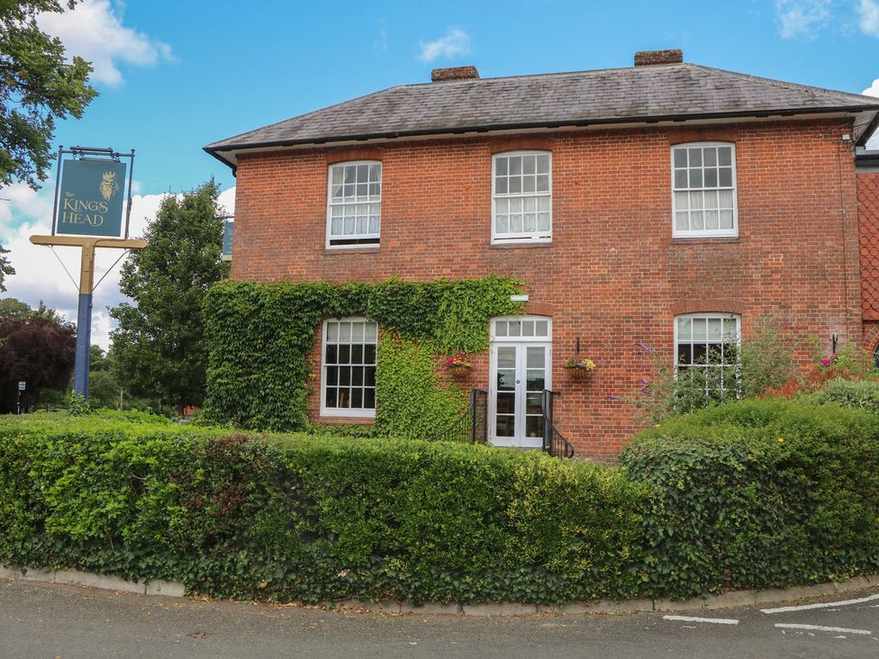 A brick building with ivy and bushes at The King's Head in Winchester