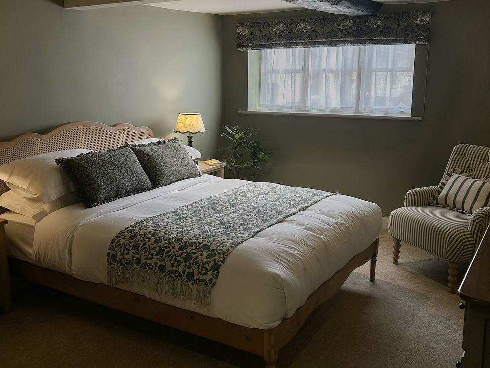 A bedroom with a bed and a chair at Skylarks in Winchester