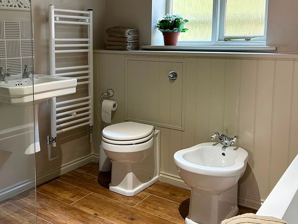 A bathroom with a toilet, bidet, sink, and towel rack at Skylarks in Winchester