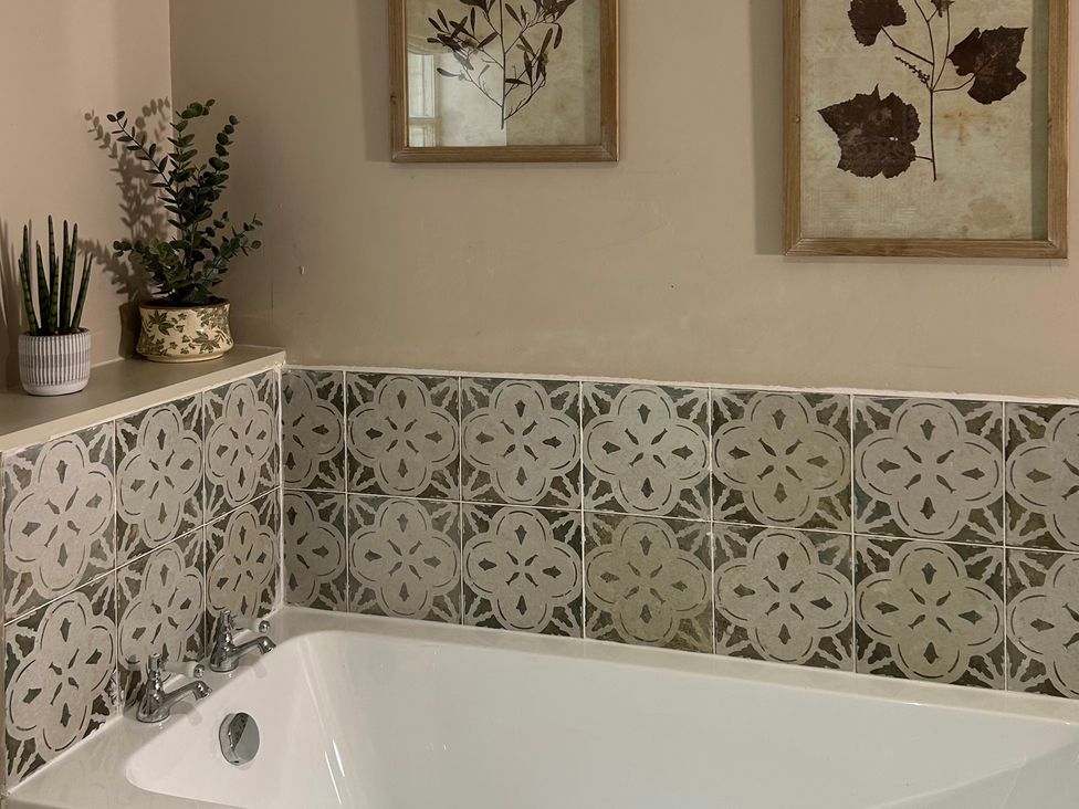 A bathroom featuring a bathtub and wall art at Skylarks in Winchester