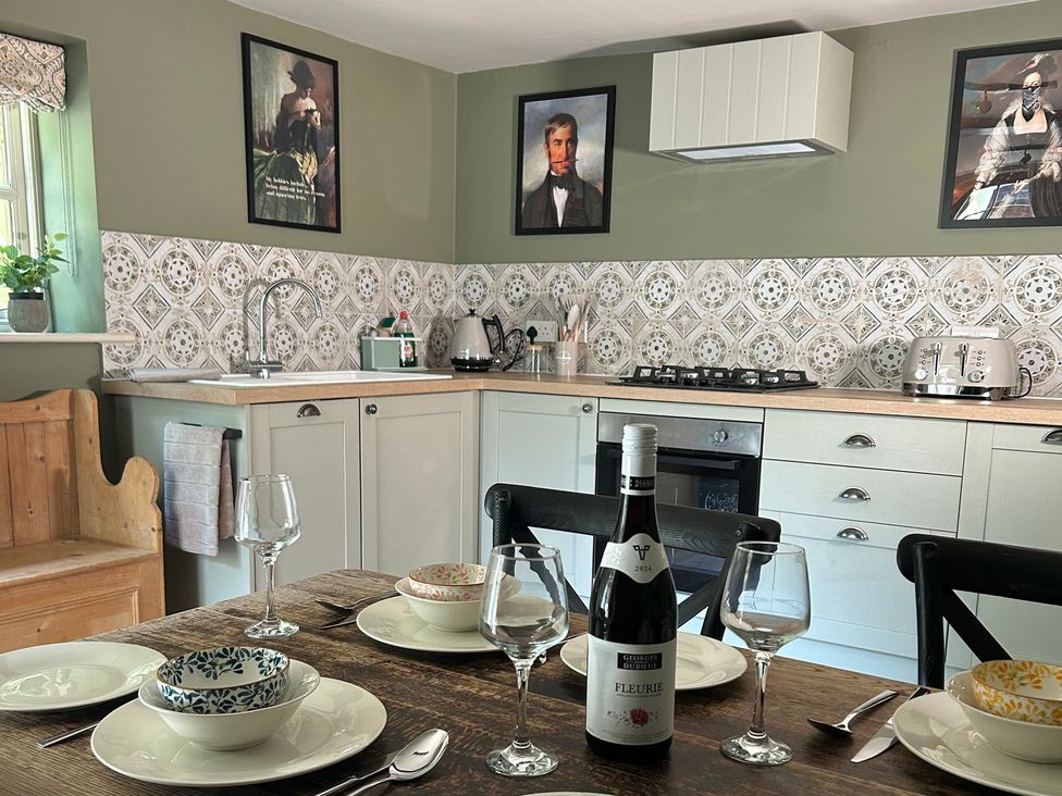 A kitchen with dining table and wine on the table at Skylarks in Winchester