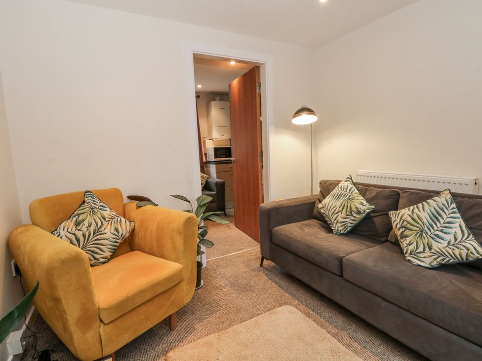 A living room with a sofa and armchair at 5 The Old Coach House Chinley