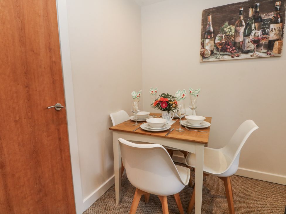 A dining room with a table set for meals at 5 The Old Coach House Chinley