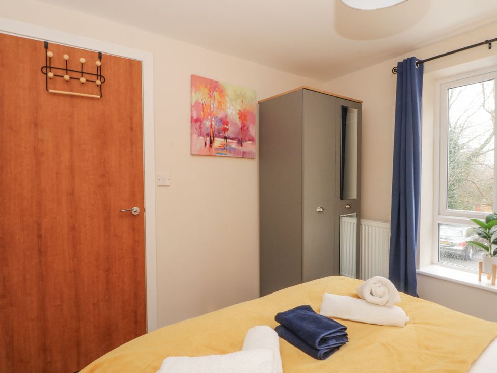 A bedroom with a wardrobe and towels on the bed at 5 The Old Coach House in Chinley