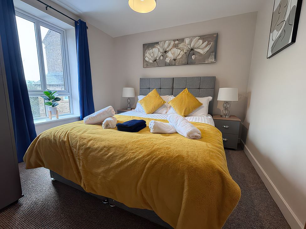A bedroom with a bed and bedside table at 5 The Old Coach House in Chinley