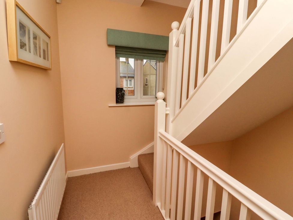 A hallway with a staircase and window at High Sea View