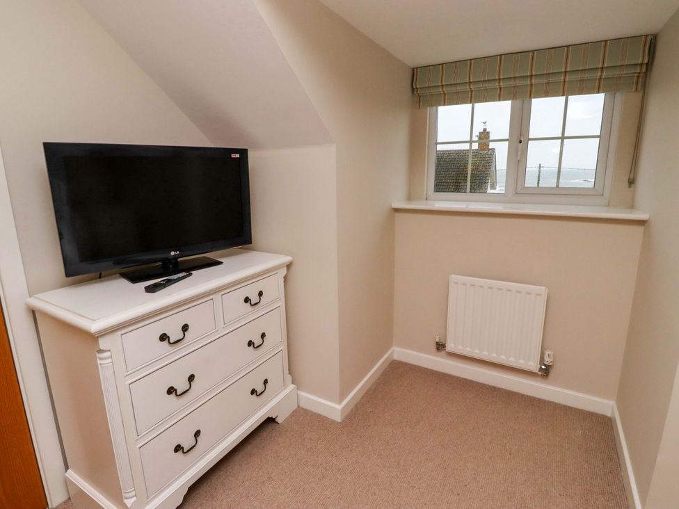 A bedroom with a television and a chest of drawers at High Sea View