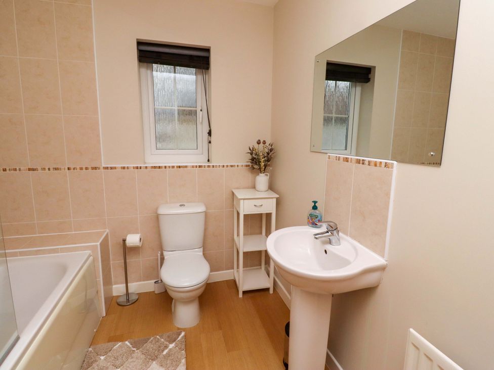 A bathroom with a sink, toilet, bathtub and window at High Sea View in 