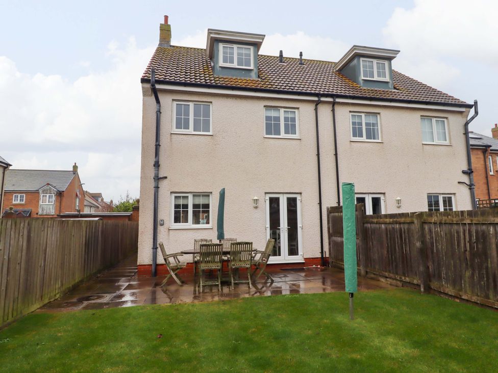 A garden with a table and chairs at High Sea View