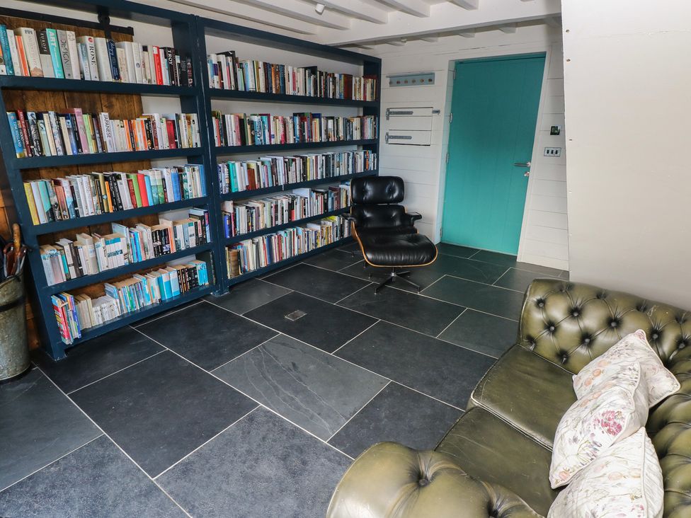 A reading room with bookshelves and a chair at The Barn in Newport