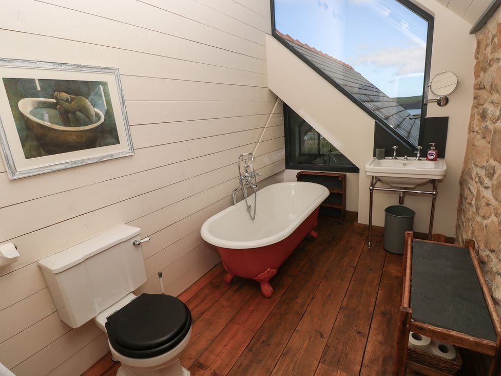 A bathroom with a bathtub, toilet and sink at The Barn in Newport