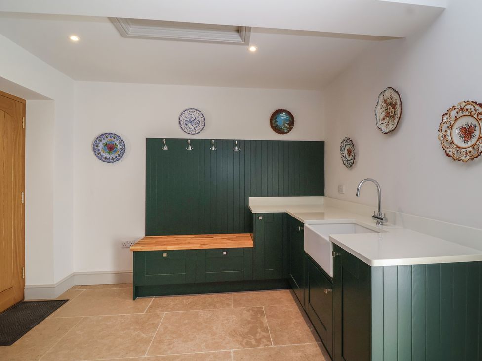 A kitchen with sink and storage at Leafield Cottage in Brockworth