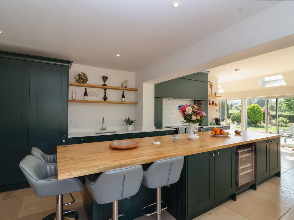 A kitchen with cabinets and a breakfast bar at Leafield Cottage in Brockworth