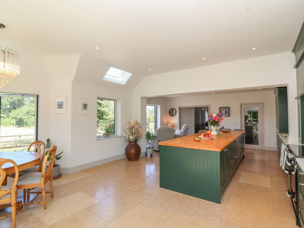 A kitchen with dining table and chairs at Leafield Cottage in Brockworth