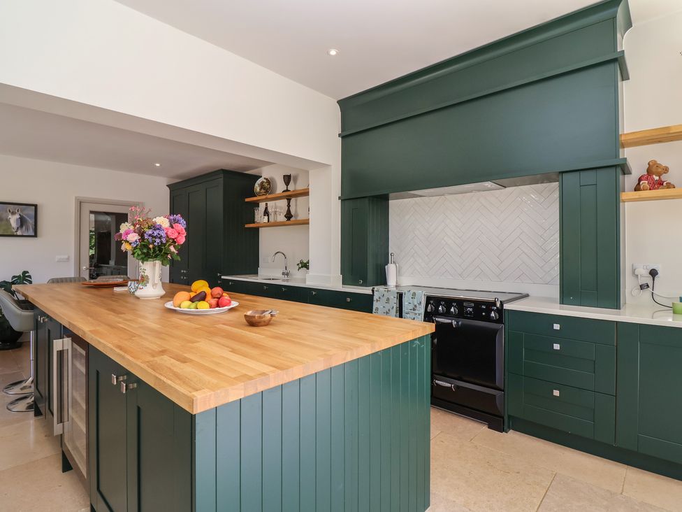 A kitchen with a central island and a stove at Leafield Cottage in Brockworth