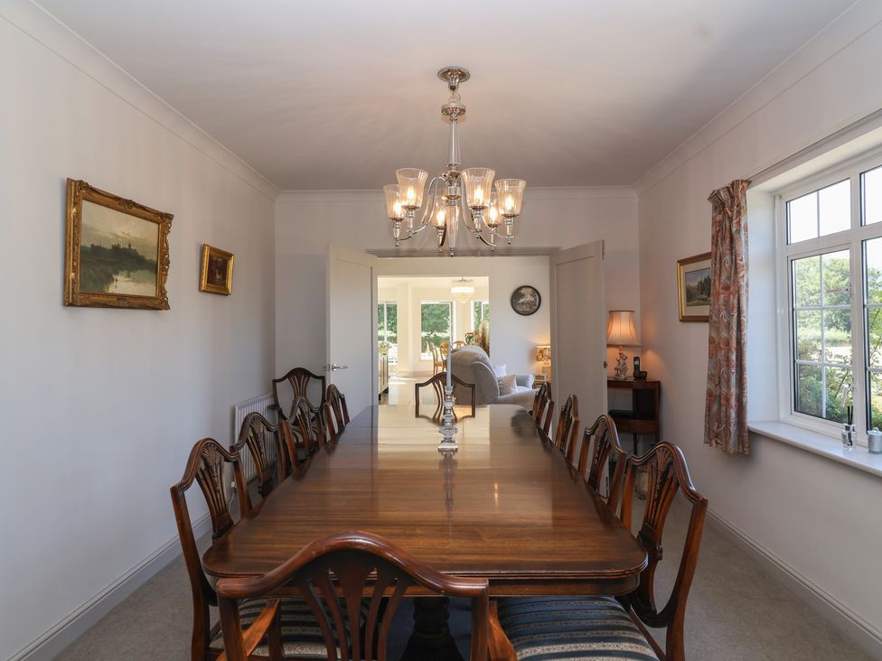 A dining room with a large table and chairs at Leafield Cottage in Brockworth