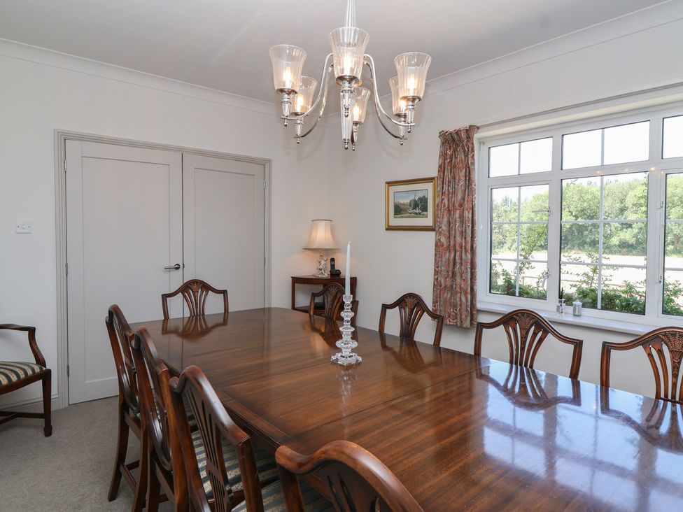 A dining room with a large table and chairs at Leafield Cottage in Brockworth