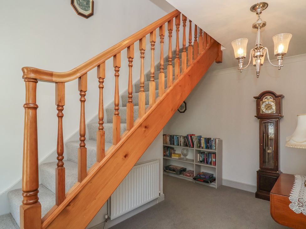 A staircase with books on a shelf in Leafield Cottage Brockworth