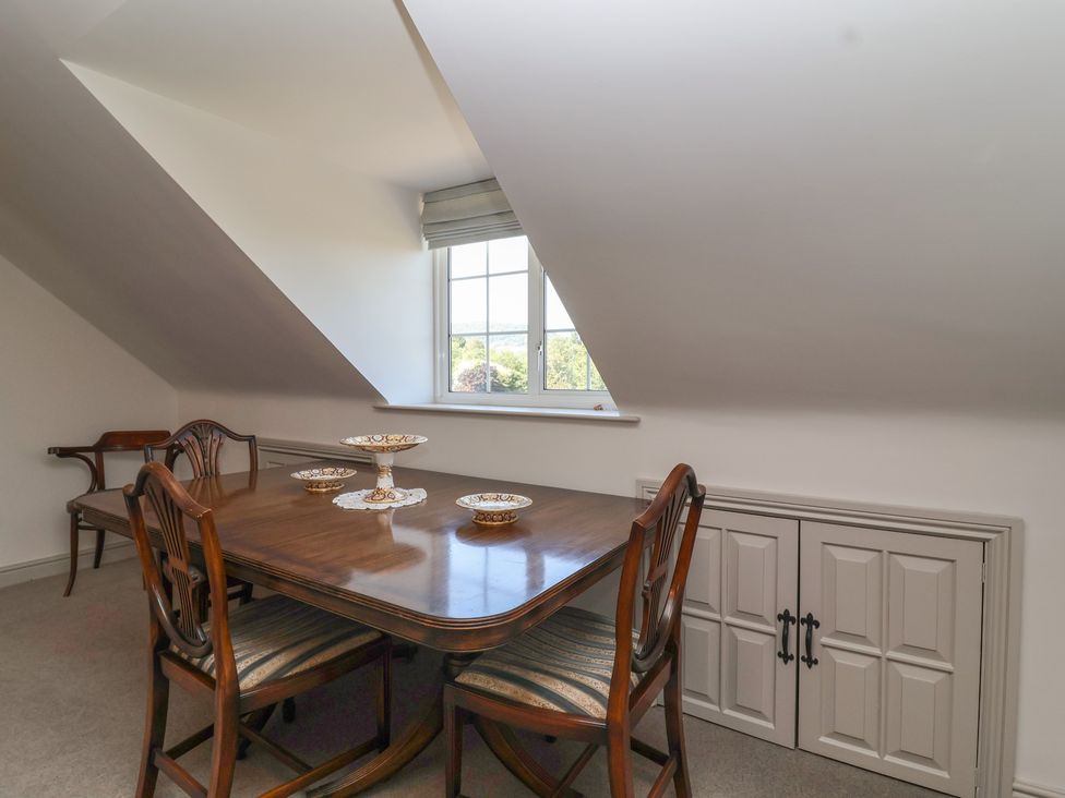 A dining room with a table and chairs at Leafield Cottage Brockworth
