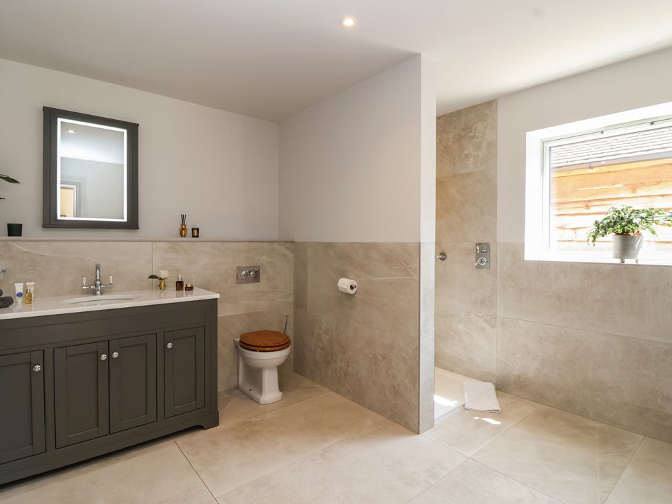 A bathroom with a sink, toilet, and shower at Leafield Cottage Brockworth